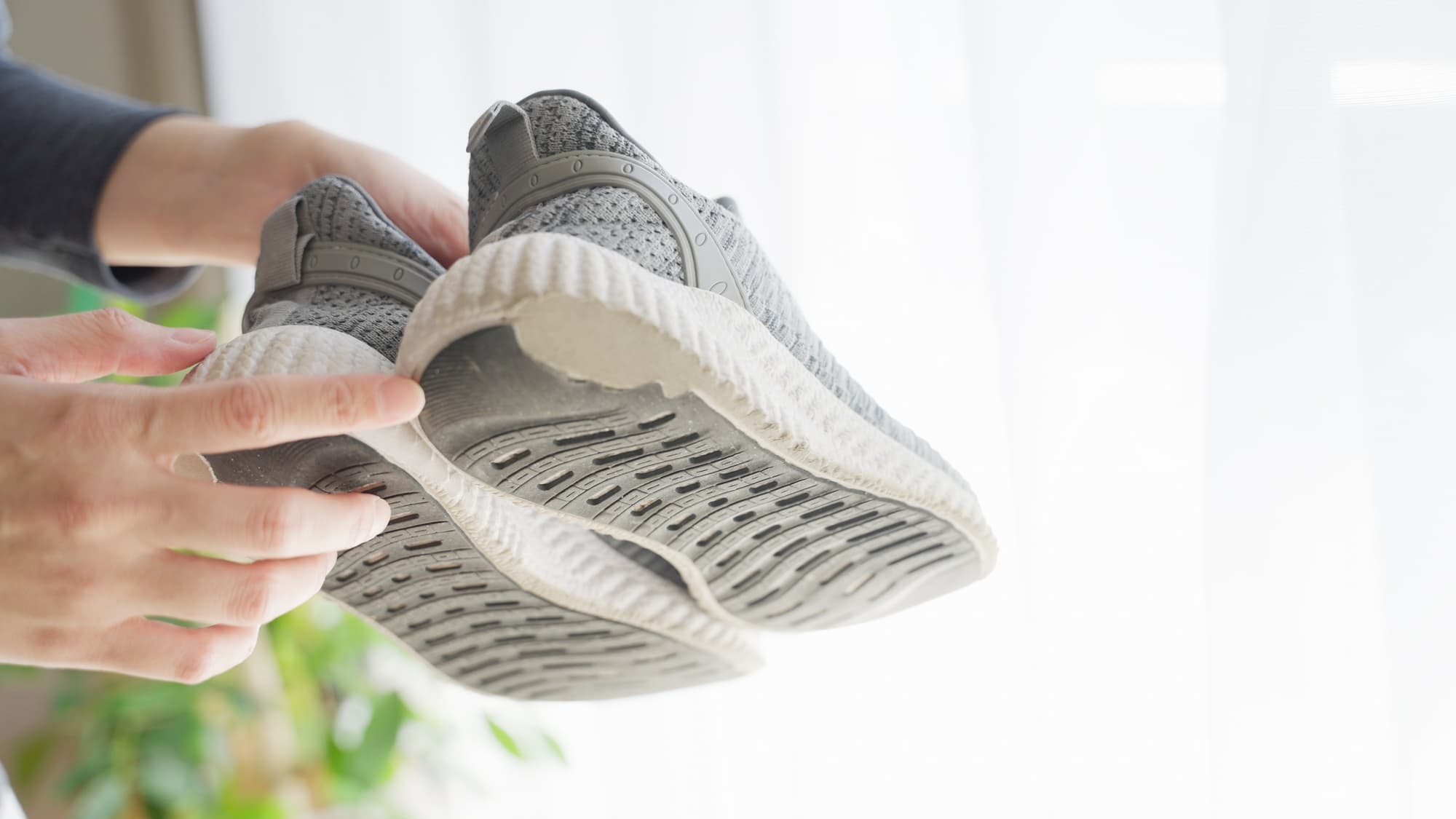 トレーニングシューズの底を指さしている手元の画像